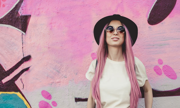 Happy stylish young hipster woman with long pink hair